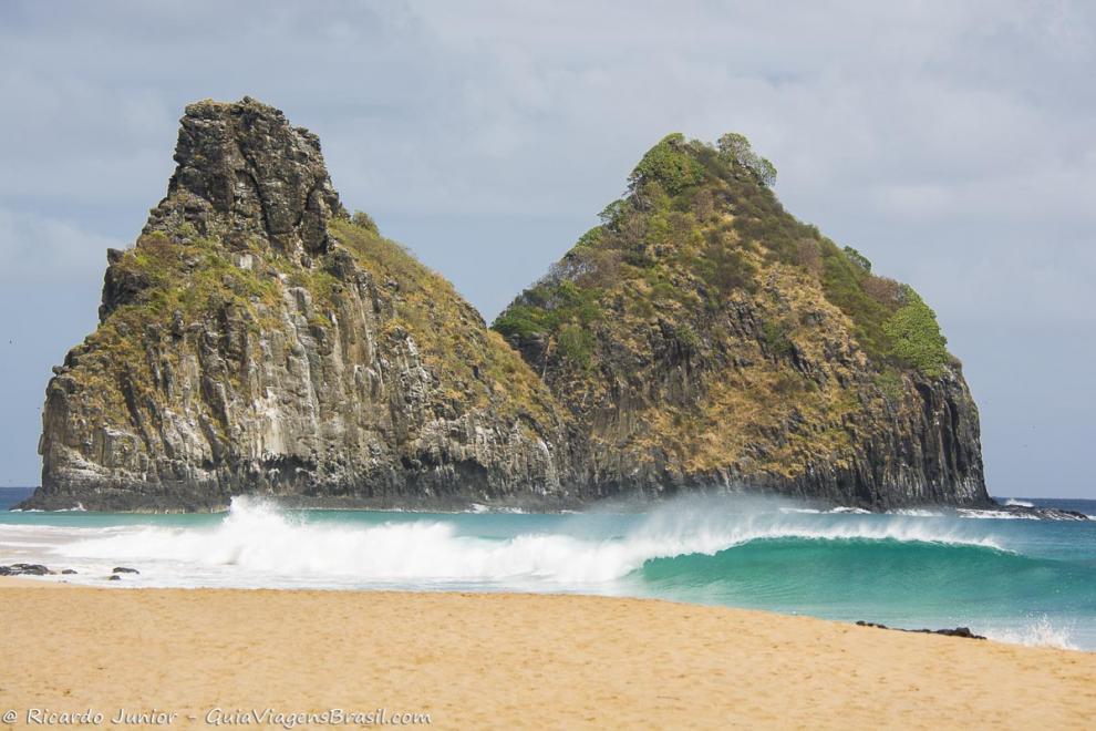 Imagem das ondas na Praia da Cacimba do Padre a ao fundo Morro Dois Irmãos.